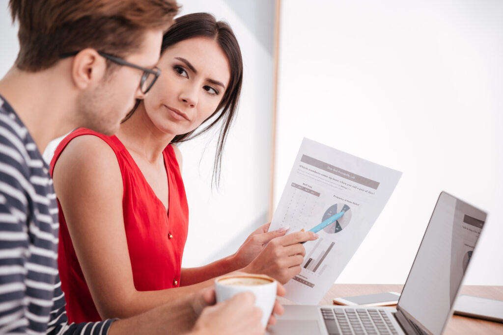 Home side view of couple with laptop and documents in office